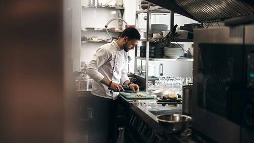 A chef dressed in a white coat working in a kitchen. 
@novokayn on Instagram